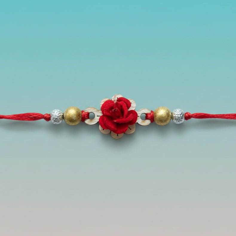 Red MDF Kairi BB Rakhi by Gifthubmart featuring a red flower centerpiece with gold and silver beads