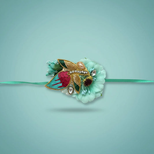 Blue Pollen Rakhi by Gift Hub Mart featuring turquoise petals and gold accents