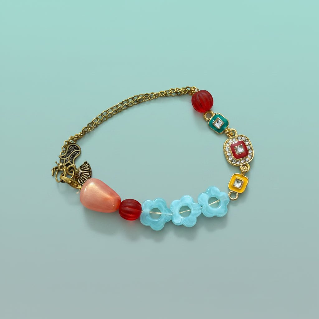 Bracelet Rakhi 100B by Gifthubmart with red bead, turquoise accents, and gold chain