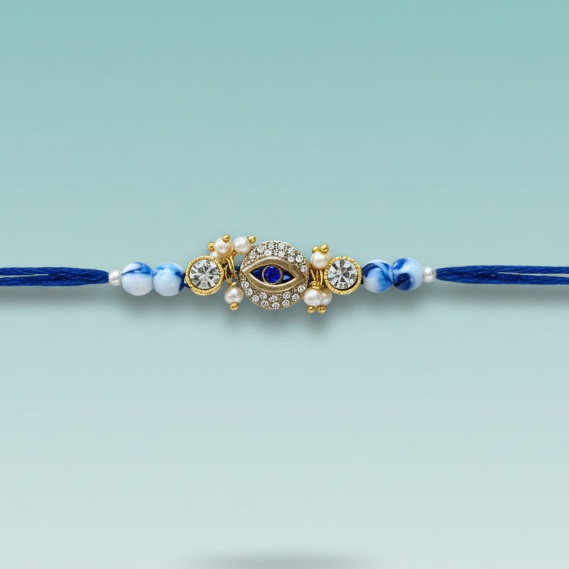 Evil Eye Blue Rakhi by Gifthubmart, blue beads with a jeweled eye charm on a blue cord