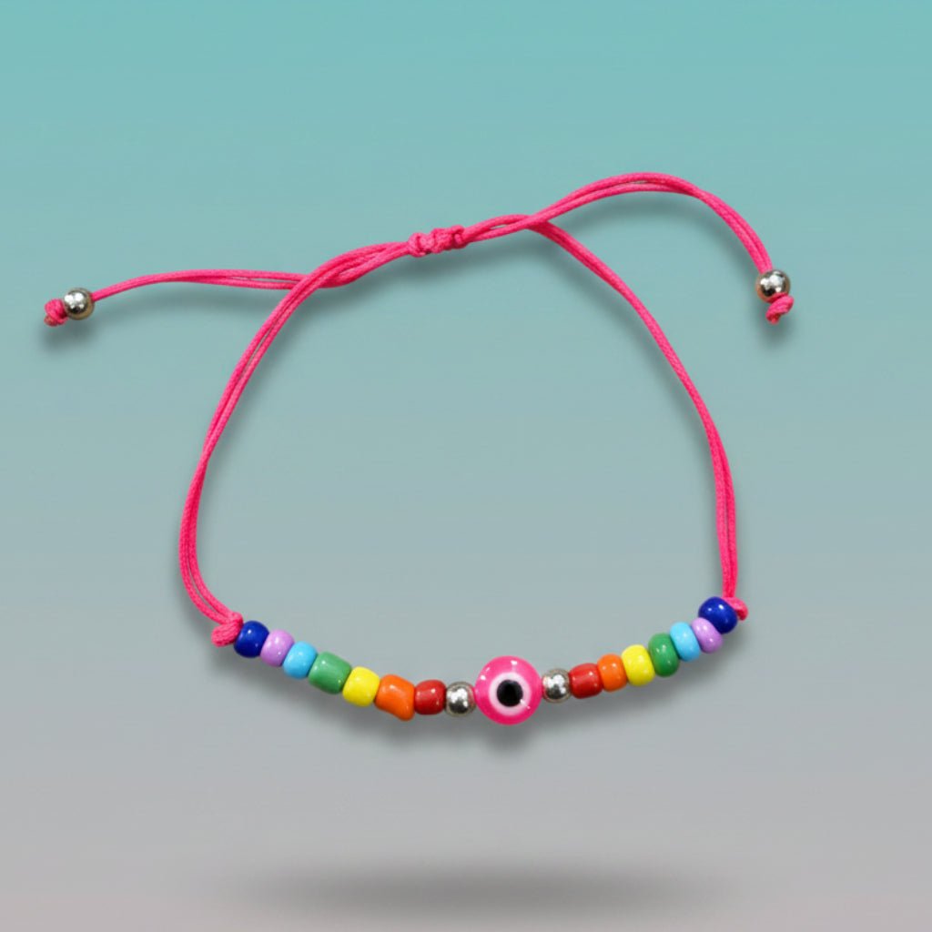 An adjustable pink string bracelet featuring a central pink and white evil eye charm, accented by small silver beads and a vibrant sequence of multi-colored beads on a light teal background.