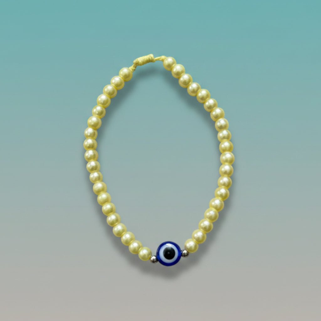 Evil Eye With Beads Bracelet featuring pale yellow faux pearls, a protective blue evil eye charm, and a yellow string closure.