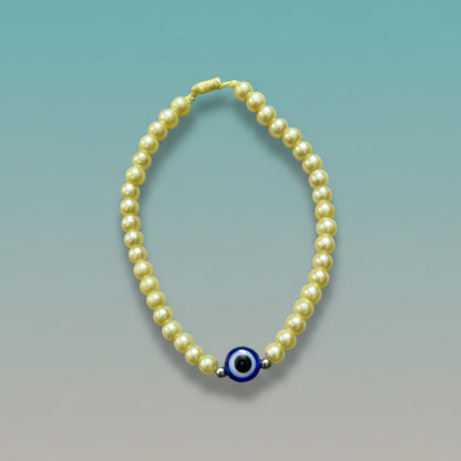 Evil Eye With Beads Bracelet featuring pale yellow faux pearls, a protective blue evil eye charm, and a yellow string closure.