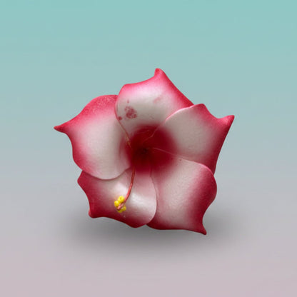 Pink and white 3D fabric flower rubber band hair tie with a yellow center.
