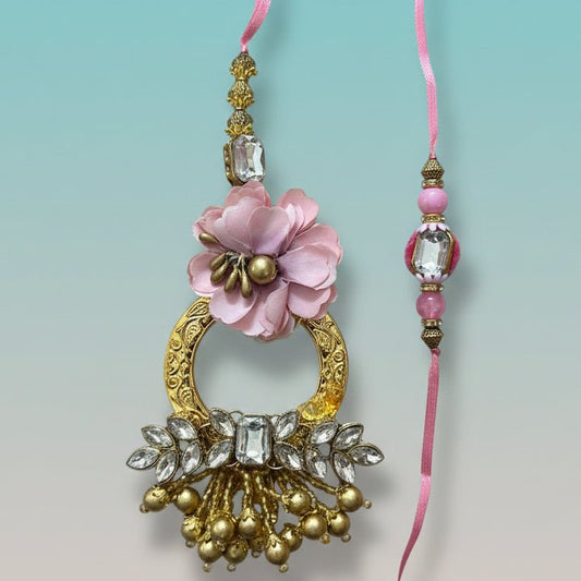 Gifthubmart Gulab Ghunghru BB Rakhi with pink flower pendant and crystal-studded gold accents.