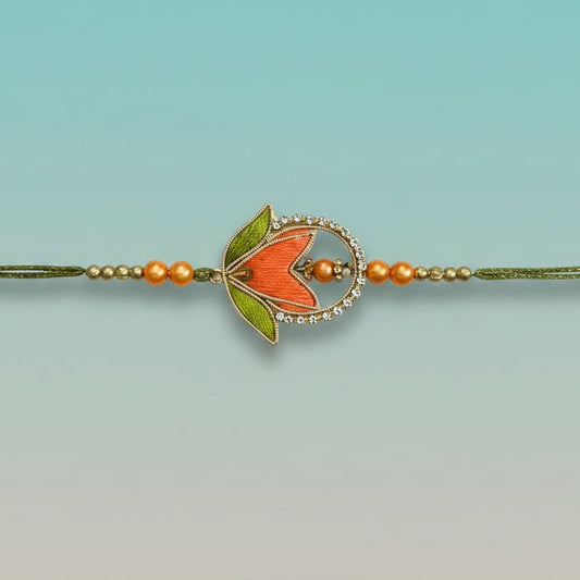 Kashida Rakhi by Gifthubmart, orange bead centerpiece with crystal halo on green cord.