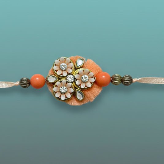 Gifthubmart Peachy Flowers Bb Rakhi with peach beads and floral charms in clear packaging