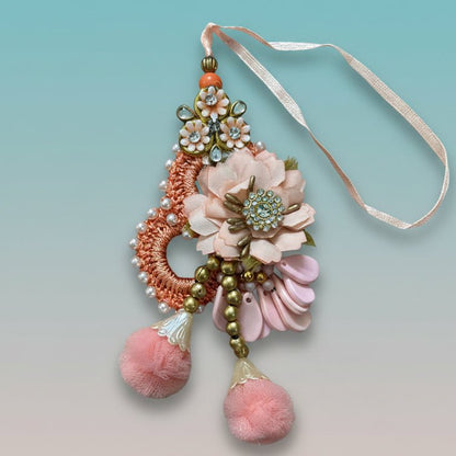 Peachy Flowers Bb Rakhi by Gifthubmart - peach floral design with beads and pink pom-poms