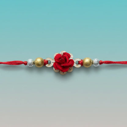 Red MDF Kairi BB Rakhi by Gifthubmart featuring a red flower centerpiece with gold and silver beads