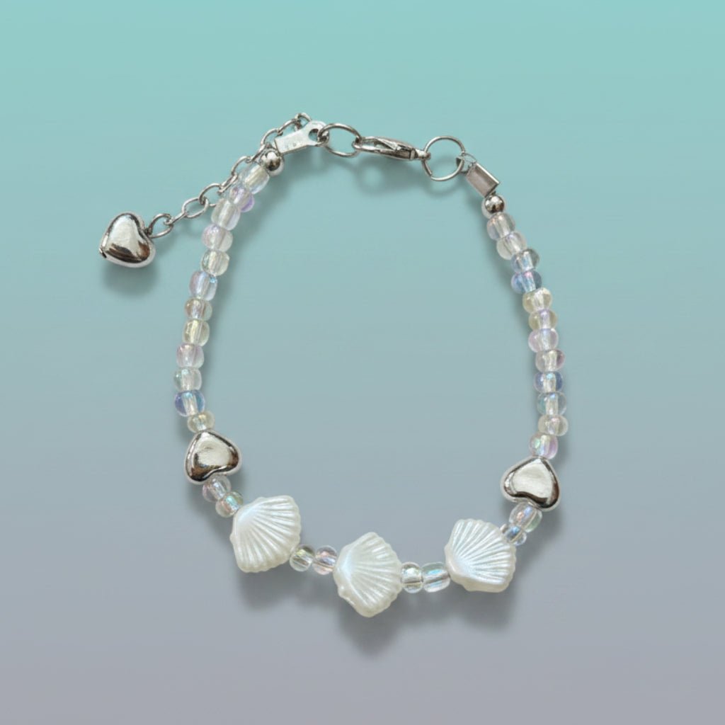 Delicate silver shell bracelet featuring white shell charms, silver hearts, and iridescent beads.