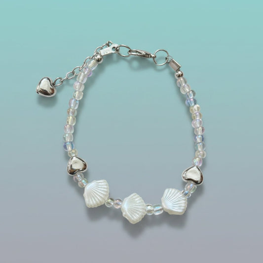 Delicate silver shell bracelet featuring white shell charms, silver hearts, and iridescent beads.