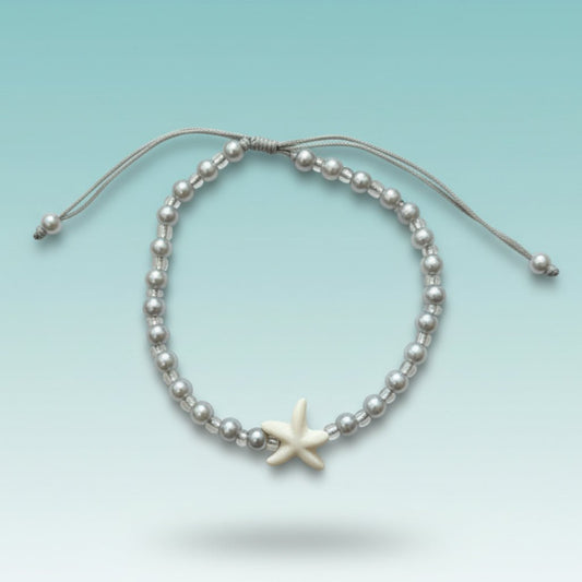 Delicate silver beaded bracelet with a white starfish charm and adjustable cord.