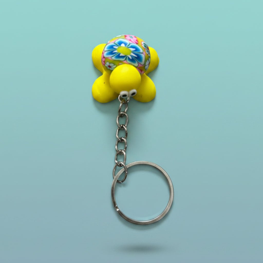 Turtle Keychain and Magnet featuring a bright yellow body and vibrant floral shell on a silver keyring.
